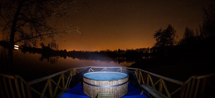 A star lit hot tub at Log House Holidays